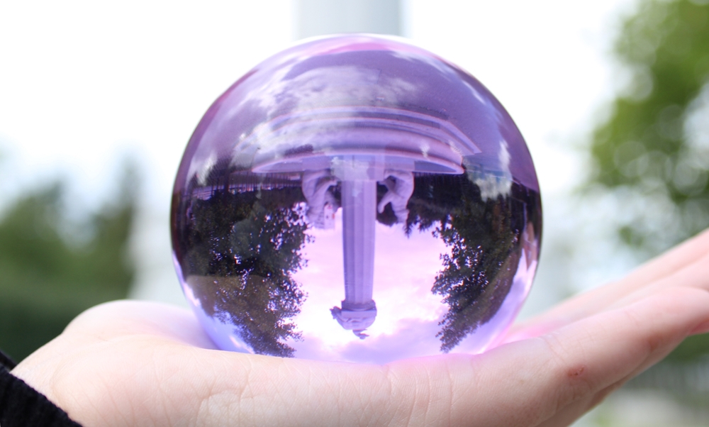 Bild von einem lila Lensball mit einem Brunnen als Motiv.